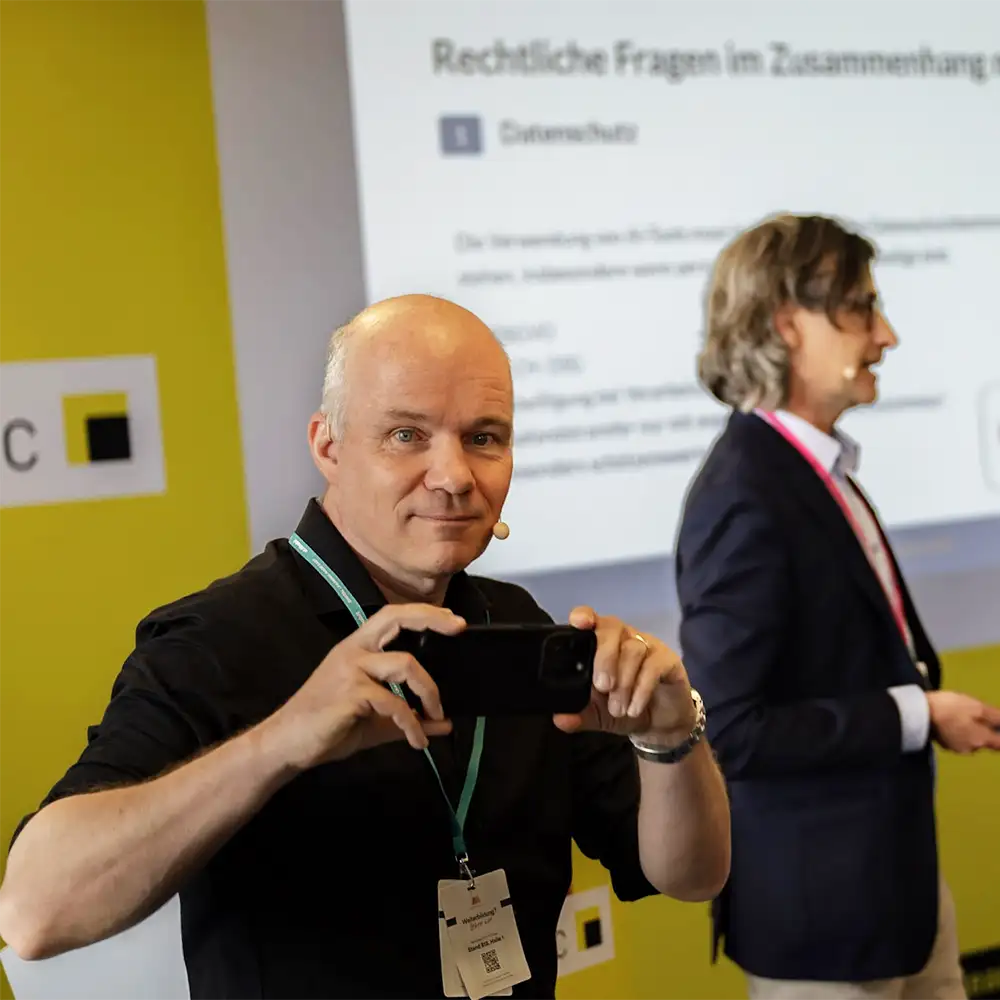 Collaboration-Design_Ueber-mich-Daniel-mit-Mobile Daniel Stoller-Schai von Collaboration Design mit Mobiltelefon in der Hand bei einem Workshop